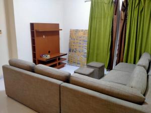 a living room with a brown couch and green curtains at 1 BHK Fully Furnished Flat in Sharjah