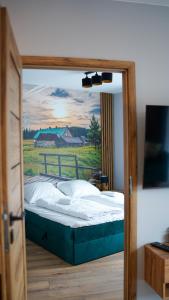 una camera da letto con un letto e un dipinto sul muro di Apartament Izerka z basenem i sauną - Stone Hill a Szklarska Poręba