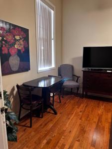 a living room with a table and chairs and a television at Hotel Belvidere in Belvidere