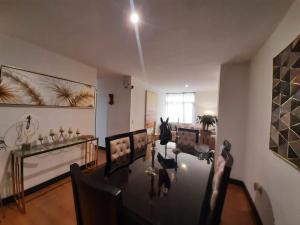 uma sala de estar com uma mesa e uma sala de jantar em CONFORTABLE Y ELEGANTE DEPARTAMENTO em Quito