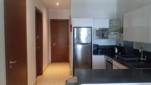 a kitchen with a stainless steel refrigerator and a hallway at Relax Waterfront Apartments. in Bijilo