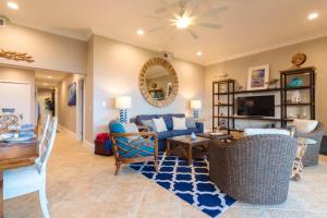 uma sala de estar com um sofá azul e uma televisão em Luxury Oceanfront ground floor condo em Kapaa
