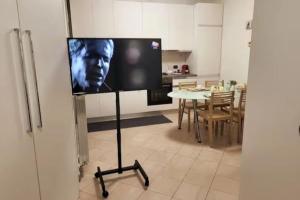 een flatscreen-tv op een statief in een keuken bij App 27 Parcheggio Privato - Accogliente Monolocale in Monza