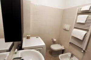 een witte badkamer met een toilet en een wastafel bij App 27 Parcheggio Privato - Accogliente Monolocale in Monza +3 foto's