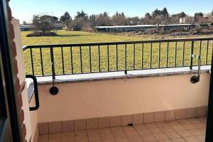 een balkon met uitzicht op een veld en een trein bij App 27 Parcheggio Privato - Accogliente Monolocale in Monza