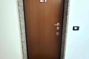 een bruine deur met het nummer erop bij App 27 Parcheggio Privato - Accogliente Monolocale in Monza