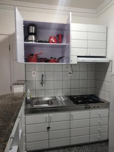 eine Küche mit einer Spüle und einem Herd in der Unterkunft Apartamento caminho do mar in Fortaleza