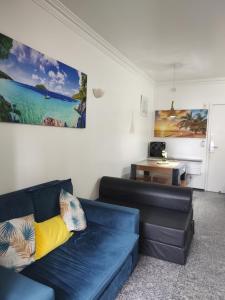 ein Wohnzimmer mit einem blauen Sofa und einem Tisch in der Unterkunft Apartamento caminho do mar in Fortaleza