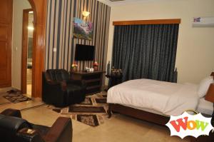 a bedroom with a bed and a desk and a chair at Baani Signature in Islamabad