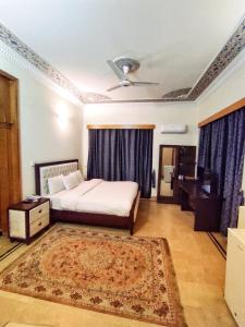 a bedroom with a bed and a ceiling fan at Baani Signature in Islamabad
