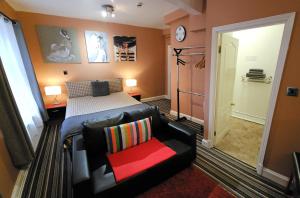 ein Schlafzimmer mit einem Bett, einem Sofa und einem Stuhl in der Unterkunft Robin 7 Lodge City Centre in Nottingham