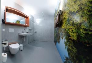 La salle de bains est pourvue de toilettes et d'une peinture de poisson sur le mur. dans l'établissement Hotel Restaurant Sokrates, à Güttingen