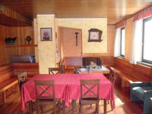 une salle à manger avec une table et des chaises rouges dans l'établissement Morgenleit, à Sauris
