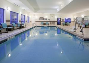 una gran piscina con sillas y mesas en Residence Inn Grand Junction, en Grand Junction