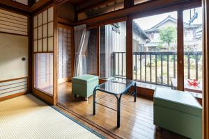a room with a bench and a table and a window at ゲストハウス　luluha in Awatabe