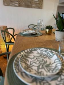 a wooden table with a plate on top of it at « Maison Sauge » et son jardin in Deauville +20 photos