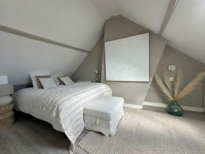a bedroom with a white bed with a white bedspread and a white at « Maison Sauge » et son jardin in Deauville