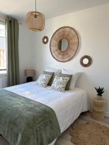 - une chambre avec un lit blanc et un miroir dans l'établissement « Maison Sauge » et son jardin, à Deauville