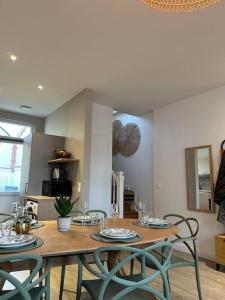 - une salle à manger avec une table et quatre chaises dans l'établissement « Maison Sauge » et son jardin, à Deauville