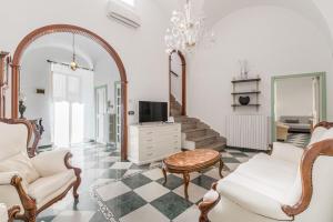 a living room with a couch and a tv at Le Bianche Suites Ostuni in Ostuni