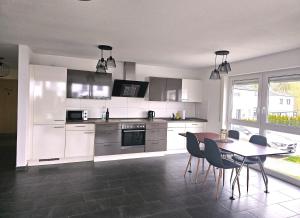 a kitchen with white cabinets and a table and chairs at MY HOME N 35/1 in Villingen-Schwenningen