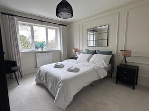 a bedroom with a large white bed with towels on it at Durham Holiday Home in Durham