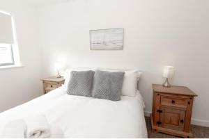 a bedroom with a white bed with pillows and a picture at Chic 1Bed Apt near Liverpool CC in Liverpool