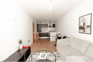 a living room with a couch and a kitchen at Chic 1Bed Apt near Liverpool CC in Liverpool