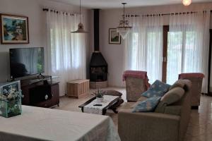 sala de estar con sofá, mesa y TV en Sítio Som das Águas, en Benedito Novo