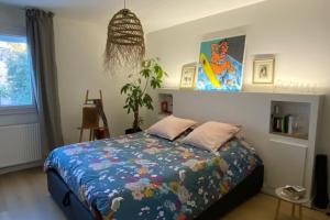 a bedroom with a bed with a colorful comforter at Lovely spacious cocoon in Montpellier in Montpellier
