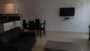 a living room with a couch and a flat screen tv at Relax Waterfront Apartments. in Bijilo