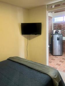 a bedroom with a bed with a flat screen tv on the wall at Depto. Equipado, 1 Habitación con estacionamiento in Tulancingo