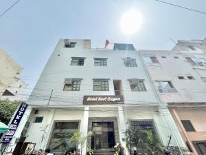 a tall white building with a sign on it at HOTEL NEEL GAGAN ! VARANASI fully-Air-Conditioned hotel at prime location, near Kashi Vishwanath Temple, and Ganga ghat in Varanasi