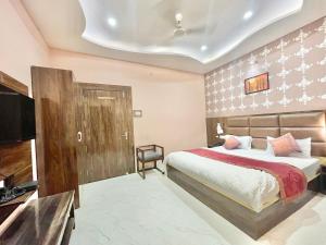 a bedroom with a bed and a flat screen tv at HOTEL NEEL GAGAN ! VARANASI fully-Air-Conditioned hotel at prime location, near Kashi Vishwanath Temple, and Ganga ghat in Varanasi