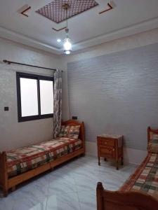 - un salon avec deux lits et une fenêtre dans l'établissement Appartement Dar Meknès, à Meknès