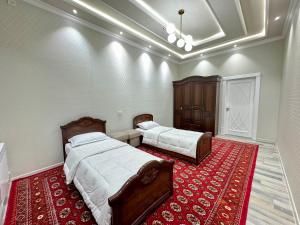 a bedroom with two beds and a red rug at Samarkand luxury apartament #8 in Samarkand