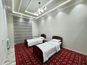 two beds in a room with a red carpet at Samarkand luxury apartament #8 in Samarkand