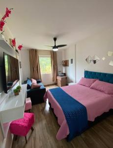 een slaapkamer met een groot bed en een bank bij BELO flat Cavalinho Branco - Aguas de Lindóia in Águas de Lindóia