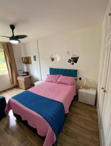 een slaapkamer met een groot bed met roze en blauwe lakens bij BELO flat Cavalinho Branco - Aguas de Lindóia in Águas de Lindóia