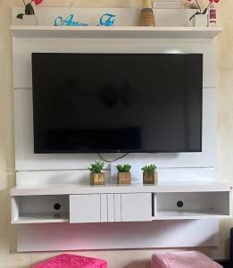 a flat screen tv sitting on a white entertainment center at BELO flat Cavalinho Branco - Aguas de Lindóia in Águas de Lindoia