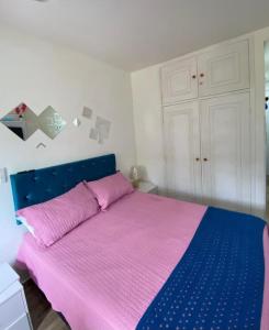 a bedroom with a bed with pink and blue sheets at BELO flat Cavalinho Branco - Aguas de Lindóia in Águas de Lindoia