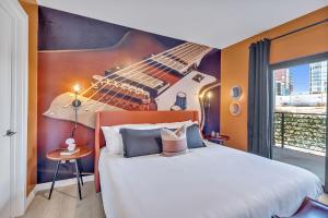 a bedroom with a large bed with a guitar on the wall at The Stage in Downtown Nashville by Nautical Properties in Nashville