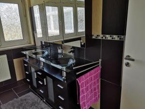 La salle de bains est pourvue d'un lavabo noir et d'une serviette rose. dans l'établissement FEWO Civrilli 5 Zi/Wohnung, à Teuchern
