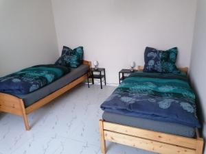 - une chambre avec 2 lits et une couette bleue dans l'établissement FEWO Civrilli 5 Zi/Wohnung, à Teuchern