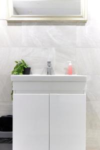 a bathroom with a white sink and a mirror at Shoreditch / Brick Lane - Studio in London