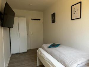 Schlafzimmer mit einem Bett und einem Flachbild-TV in der Unterkunft 5-Bett Wohnung im Boardinghaus Elisabeth in Dinslaken