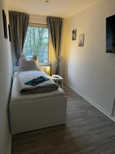 ein kleines Schlafzimmer mit einem Bett und einem Fenster in der Unterkunft 5-Bett Wohnung im Boardinghaus Elisabeth in Dinslaken