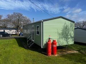 two red fire hydrants next to a green trailer at Sea View, Thorness Bay in Porchfield