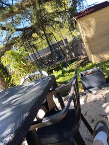 una persona seduta su una panchina accanto a un tavolo da picnic di Appartement Noméo a Saint-Privat-des-Vieux