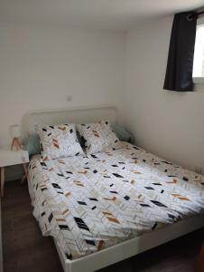 una camera da letto con un letto con un piumone bianco di Appartement Noméo a Saint-Privat-des-Vieux